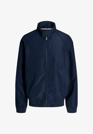 Tumesinine tõmblukuga jakk, millel on püstitõstetav krae, kaelal nööpidega kinnitamine, pikad varrukad, küljetaskud ning elastne vöökoht ja varrukasuu.