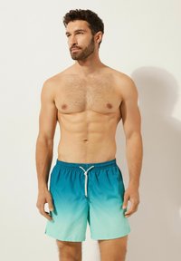 Turkosa badshorts med en gradientdesign, med resårmidja och dragsko. Tillverkade av lätt, slät tyg.