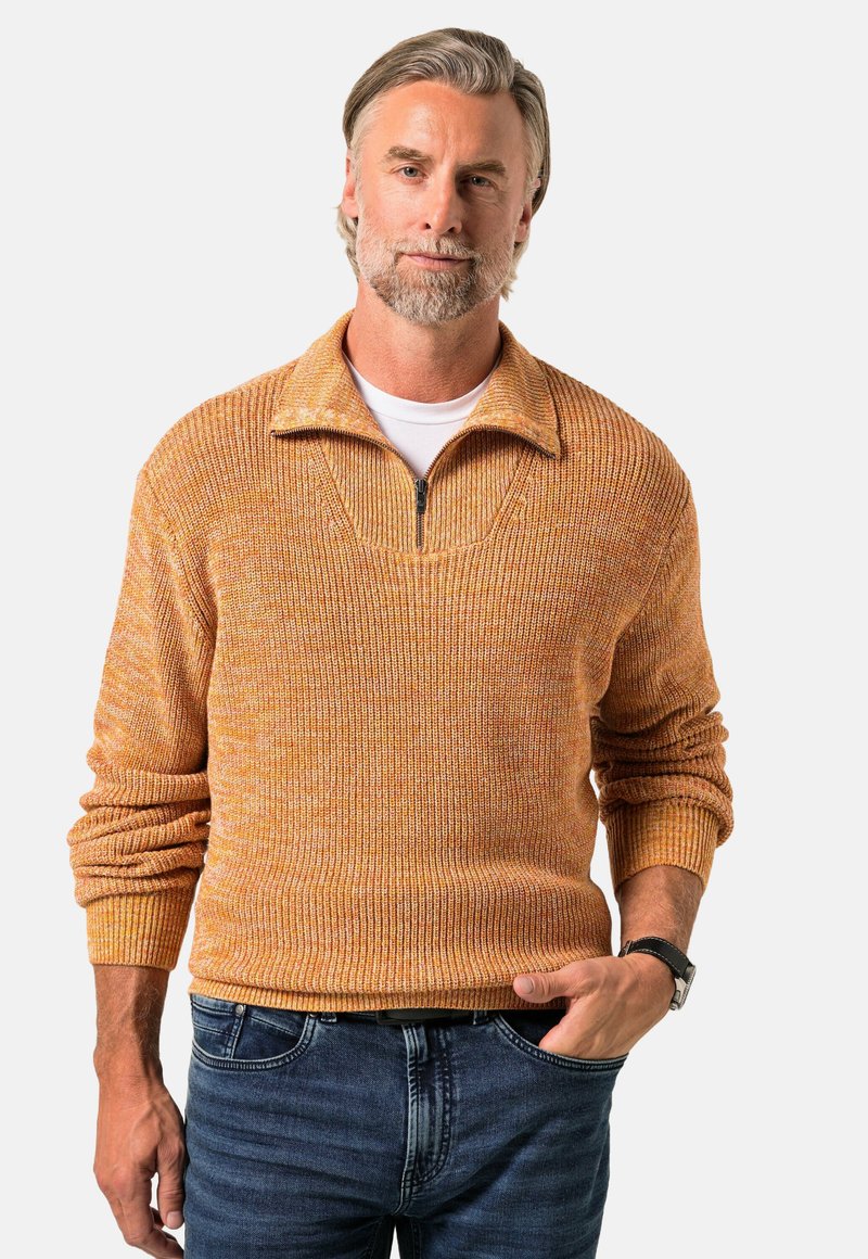 Pullover-Sweatshirt mit einem halben Reißverschlussdesign, strukturiertem orangefarbenem Strickmuster, gerippten Bündchen und Saum, kombiniert mit dunkelblauen Jeans.