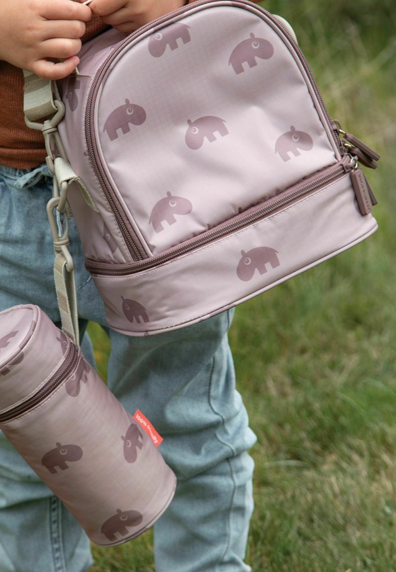 Sac à dos rose avec un motif d'éléphant subtil, fermeture à glissière, et un contenant cylindrique assorti, tous deux présentant une texture lisse et une sangle réglable.