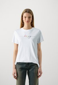 Valge puuvillane t-särk, mille rinnaosal on mitmevärviliste niitigega broderitud "happy". Ümmargune kaelus ja lühikesed varrukad.