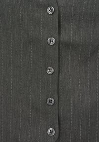 Tissu gris foncé avec de fines rayures verticales blanches et une rangée de six boutons noirs brillants à quatre trous au centre.