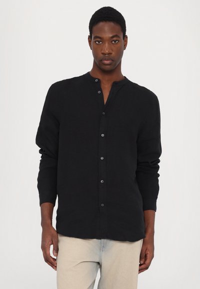 Camicia nera a maniche lunghe con bottoni, realizzata in lino, con colletto rotondo, una trama sottile e bottoni scuri sul davanti.