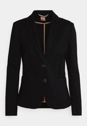 Blazer preto com um design de um único botão, duas bolsos frontais e uma lapela de cetim. Apresenta dois botões e um forro bege no interior.