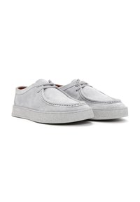 Zapatos de ante grises con punta redondeada, que presentan una suela de goma blanca texturizada y un diseño de lazado minimalista. Estética sofisticada y simple.