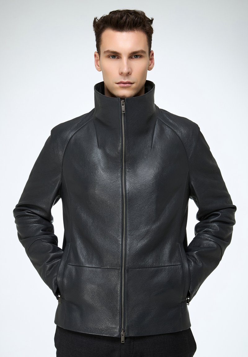 Schwarze Lederjacke mit hohem Kragen, Seitentaschen und glatter Textur. Verfügt über einen Frontreißverschluss und strukturierte Designelemente.