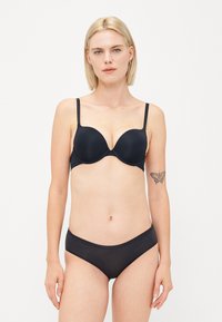 Zwarte ondergoed beha met gladde cups, verstelbare bandjes en bijpassende zwarte bikini slip. Gemaakt van rekbare stof voor comfort.