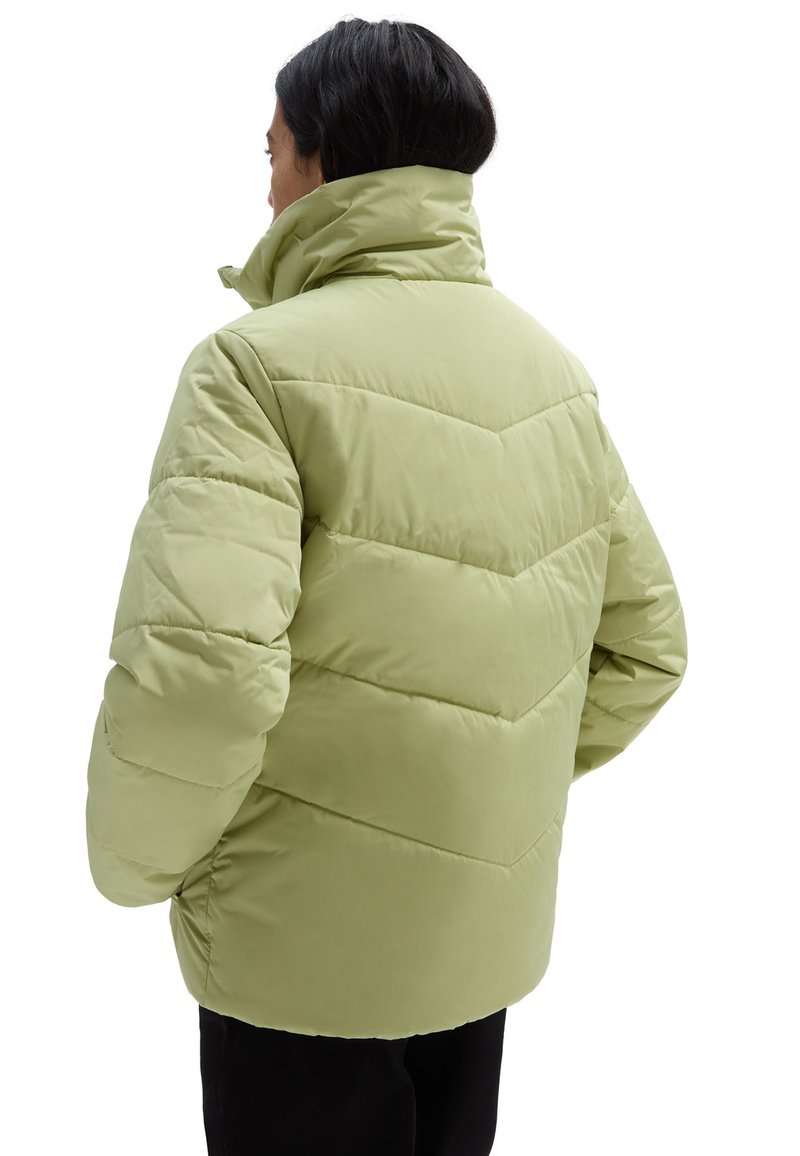 Padded jacket w jasnozielonym kolorze z wysokim kołnierzem, z przeszyciami w zygzak i luźnym krojem. Miękka faktura z bocznymi kieszeniami.
