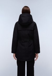 Sort parka-jakke med hætte, elastisk talje og lange ærmer. Materialet virker glat med en mat finish. Enkel design, ingen synlige mønstre.