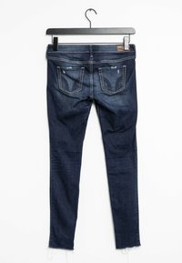 Mörkblå slim fit jeans i denim. Har fem fickor, fransad fåll och subtila slitningar på baksidan. Minimal sömnad synlig.