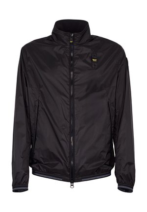 Giacca leggera nera con zip, collo alto, polsini elastici, tasche laterali e piccolo logo giallo sul petto.