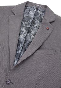 Blazer grigio a righe con colletto a punta, chiusura con un bottone e una fodera interna a motivo decorativo con design a foglie.