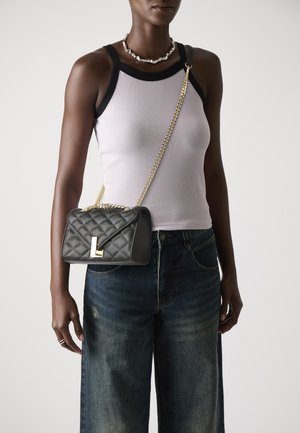Černá prošívaná kožená crossbody taška se zlatým řetízkem, s klopovým uzavíráním a výrazným zlatým akcentem ve tvaru písmena "L".