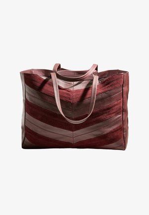 Liela liela soma ar tumši sarkanas un rozā zivju kaulu raksta ādas un zamšādas paneļiem, kurā ir divas garas rozā rokturi.