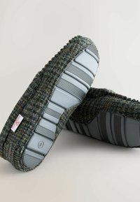 Grau und mehrfarbige Wollhausschuhe mit Gummisohlen. Texturierte Oberseite mit einem gewebten Muster und einer robusten, geriffelten grauen Laufsohle.