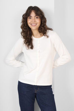 Witte lange mouwen cardigan van zacht breiwerk, met een ronde halslijn en een knoopsluiting met subtiele textuur. Gekocht met donkere jeans.