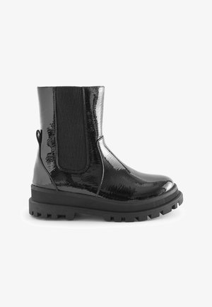 Bottines noires patinées avec des panneaux latéraux élastiques à nervures, tige texturée, languette de tirage et semelle en caoutchouc épaisse.