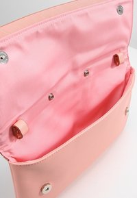 Borsa a spalla sintetica rosa con esterno liscio, interno aperto e hardware in argento. Presenta chiusure a scatto e foderatura in tessuto.