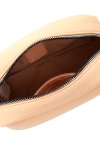 Borsa in pelle color pesca con texture a grani, chiusura superiore a zip e rivestimento in tessuto beige. L'interno presenta una piccola tasca.