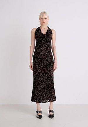 Leopardprint halter neck jurk met een aansluitende silhouet, gemaakt van zachte fluwelen stof, eindigend net onder de knie. Zwarte hoge hakken.