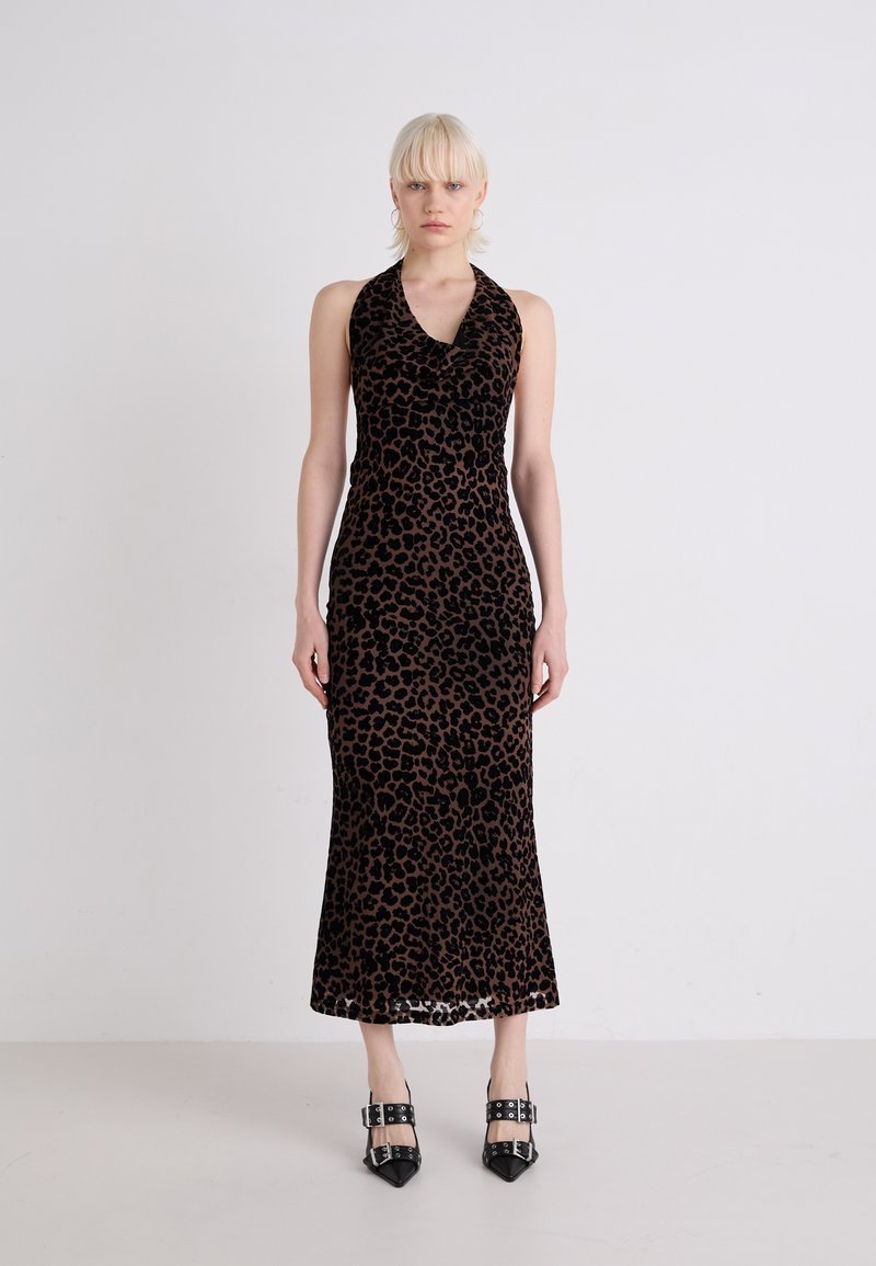 Obleka s halter vratu v leopardjem vzorcu, s prilegajočo silhueto, izdelana iz mehkega žameta, ki sega pod kolena. Črne visoke pete.