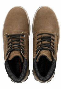 Botas de cuero marrón con cordones negros, forro de felpa gris y suelas de goma. Punta redondeada y detalles de costura reforzada. Plantilla de espuma con memoria.