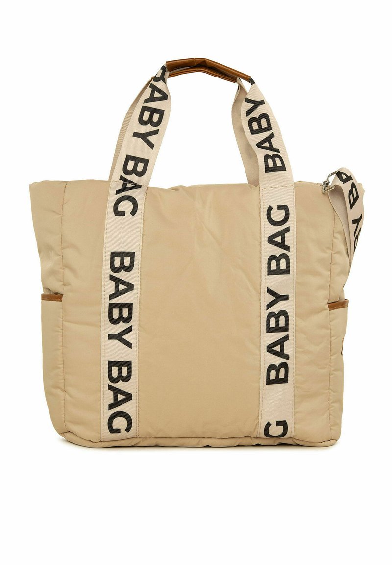 Bežs bērnu soma ar mīksto tekstūru, ar melniem "BABY BAG" siksnām, sānu kabatu un koka graudu rokturi. Taisnstūra forma.
