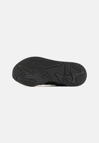 Schwarze Sportledersohle mit unterschiedlichen strukturierten Profilmustern und einem kleinen rechteckigen Logo in der Nähe der Ferse auf weißem Hintergrund.