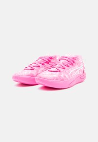 Een paar felroze sneakers met een patternd ontwerp, witte zijkanten en roze veters op een witte achtergrond.