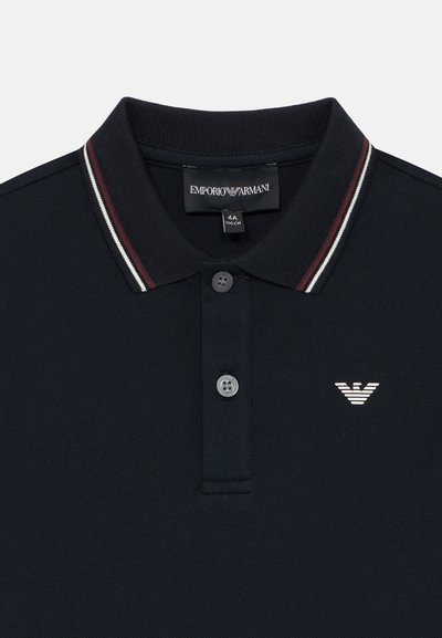 Mornarsko polo majica z ribastim ovratnikom, ki ima rdeče in bele črte, dvema gumboma in bešivanim logotipom na prsih.