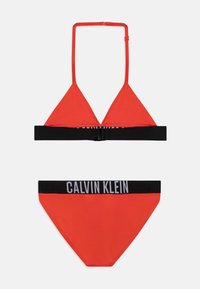 Rød bikini-sett med trekantet topp med haltersnorer og svart midjebånd med 'CALVIN KLEIN' tekst på bunnen. Glatt tekstur.