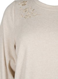 Maglione beige a maniche lunghe con una finitura leggera e testurizzata. Presenta ricami floreali in oro sulla spalla per un tocco di dettaglio aggiuntivo.
