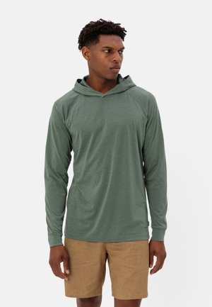Felpa verde a maniche lunghe con una vestibilità rilassata, caratterizzata da un colletto a V e una texture morbida, abbinata a pantaloncini marrone chiaro.