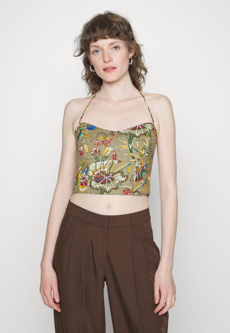 Top verde cropped com bordados florais coloridos, alças finas e decote reto, combinado com calças castanhas de cintura alta.