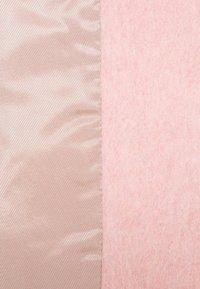 Dos muestras de tela adyacentes: una en satén rosa claro brillante y la otra en un suave fieltro rosa texturizado con una superficie ligeramente borrosa.