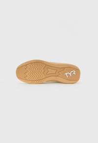 Mønsteret på en tan sportsko sål med "TYR" logo og "CXT-2" mærkning på en ensartet lys baggrund.