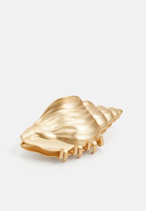 Goldfarbene, muschelförmige Schale mit glatter, glänzender Oberfläche; mit gerippten Kanten und einem breiten, geschwungenen Design. Geeignet für dekorative Zwecke.