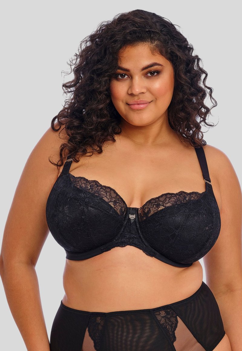 Reggiseno in pizzo nero con stecche e dettagli ricamati. Presenta una chiusura con ganci al centro e spalline regolabili per una vestibilità perfetta.