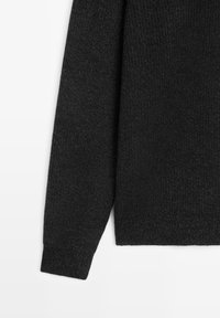 Zwarte gebreide trui met een gestructureerde stof, lange mouwen en een rechte zoom. Het materiaal lijkt zacht en warm.