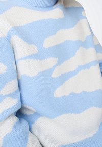 Lichtblauwe gebreide trui met zachte witte wolkenpatronen, geribde kraag en een gezellige textuur. Casual ontwerp met een ontspannen pasvorm.