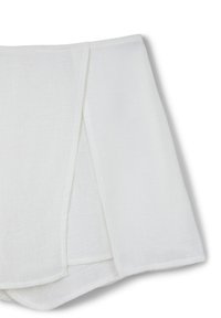 Tessuto di lino bianco drappeggiato con pieghe diagonali, caratterizzato da una consistenza morbida e un aspetto leggermente traslucido. I bordi sono rifiniti con cura.