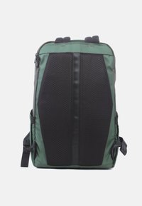 Rucksack mit einem grünen Stoffkörper, schwarzen Netzpaneelen, Obergriffen, verstellbaren Trägern und einem schlanken, winkligen Design.
