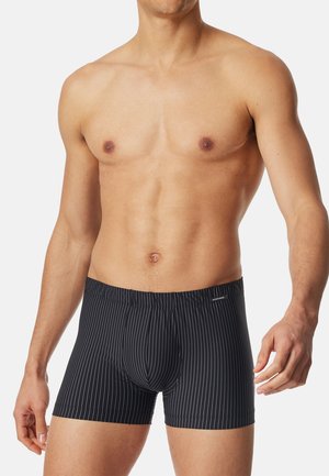 Boxers noirs à rayures fabriqués dans un tissu lisse et extensible. Comprend une taille élastique et une coupe ajustée.