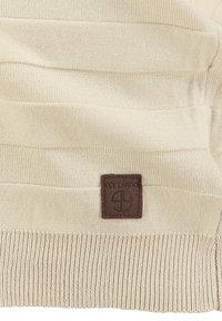 Jersey de punto beige con rayas texturizadas y un dobladillo acanalado. Incluye una etiqueta de cuero marrón con la marca "KEY LARGO".