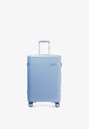 Lichtblauwe harde koffer met verticale ribbels, uitschuifbare handgreep, vier zwenkwielen en Wittchen-merklogo aan de voorkant.