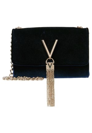Welwetowa torebka na ramię w granatowym kolorze z złotym łańcuszkiem na pasku. Posiada wyraźne złote logo w kształcie litery V z ozdobnym chwostem ze złotego łańcuszka. Kompaktowy, prostokątny kształt.