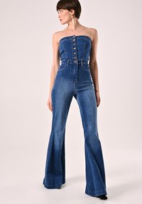 Jeansjumpsuit in donkerblauw, strapless ontwerp met bovenste knopen, hoge taille en uitlopende pijpen. Soepele textuur en getailleerde silhoutte.