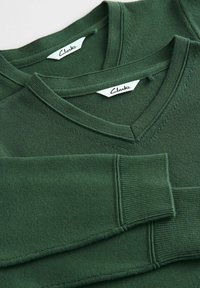 Groene katoen V-hals truien met geribbelde mouwen en hals; voorzien van een geweven label met "Clarks" op elke kraag.