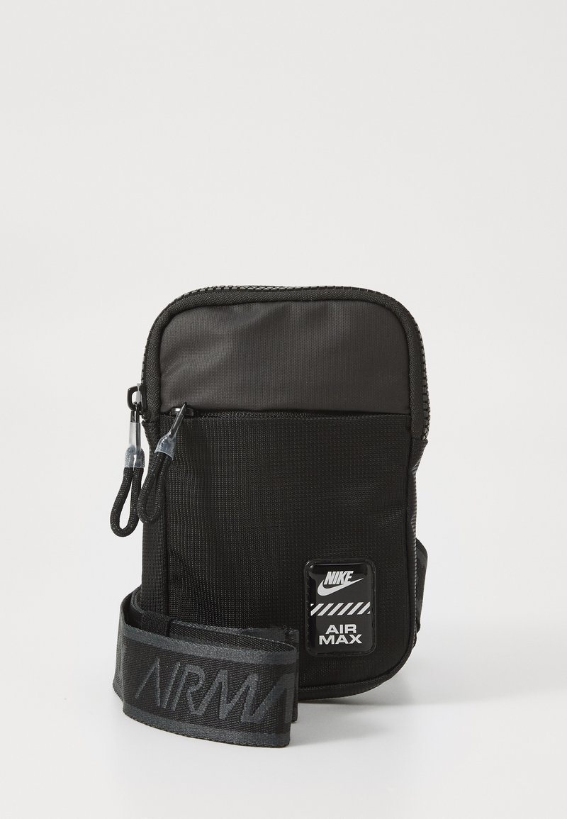 Geantă crossbody din nailon negru, cu suprafață texturată, închidere cu fermoar și curea ajustabilă, având imprimeu "AIR MAX" și logo-ul Nike.