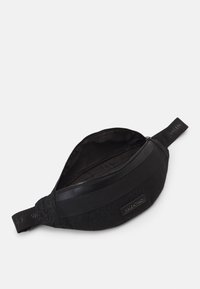 Svart tygmidjeväska med präglat logomönster, rundad form, dragkedja och ett märkt rem. Slät innersida.